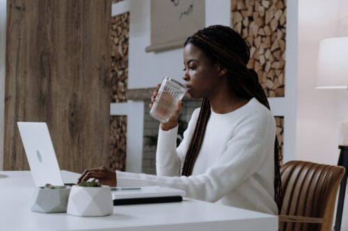 Woman in White Long Sleeve Shirt Sitting at the Table